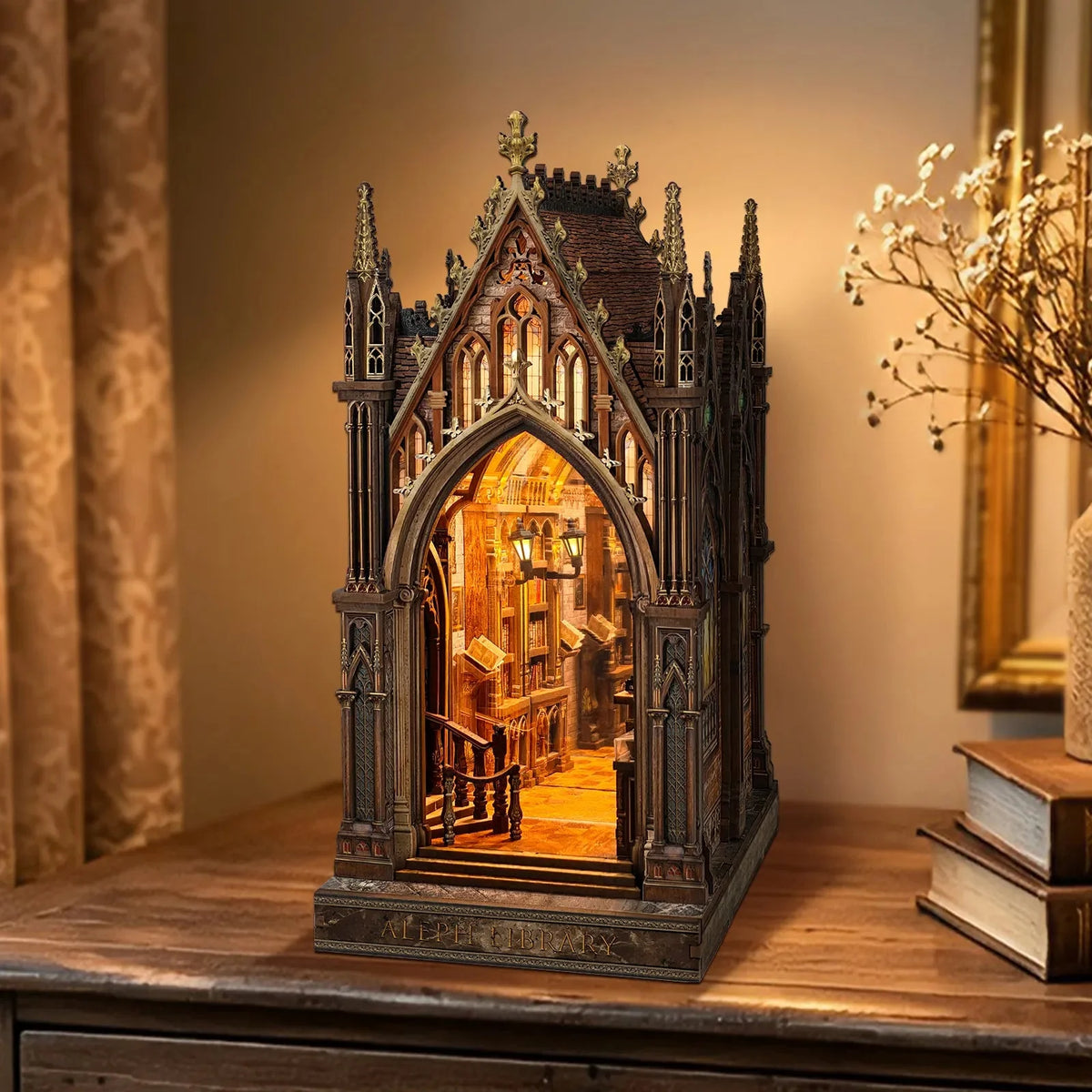 Aleph Library miniature Gothic library displayed beside a vase of dried flowers.