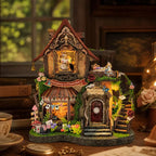 Dreamy Cottage miniature house with a rabbit in the upper window and flowers around the entrance.