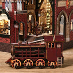 Close-up of the Hogsmoor Station locomotive on the track beneath the station arch.