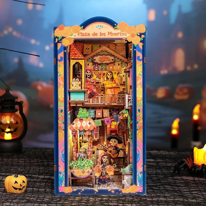 Plaza de los Muertos book nook with colorful banners, marigolds and miniature skeleton figures.
