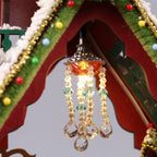 Close-up of a glowing chandelier beneath the Snowy Christmas Lodge roof.