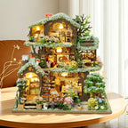 Time Treehouse snow-roof edition displayed beside a window, with white-tipped foliage and warm lights.